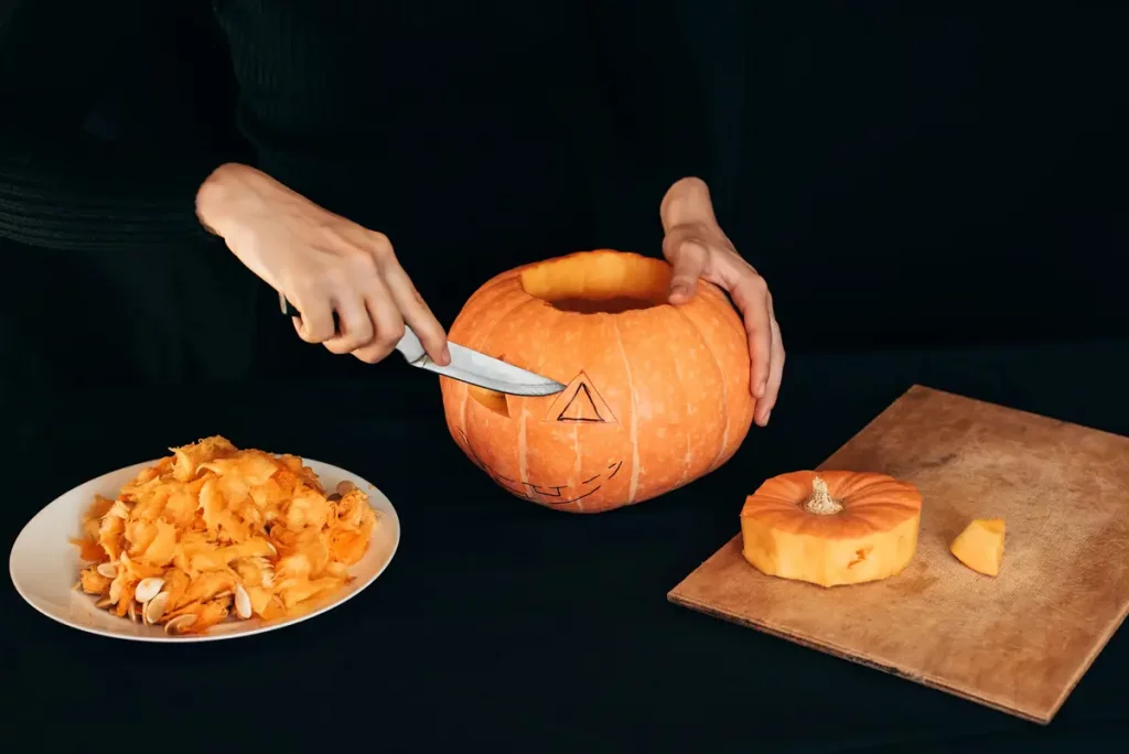 hands cutting pumpkin