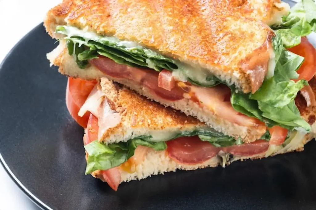 Healthy spinach tomato and cheese sandwich isolated on white background