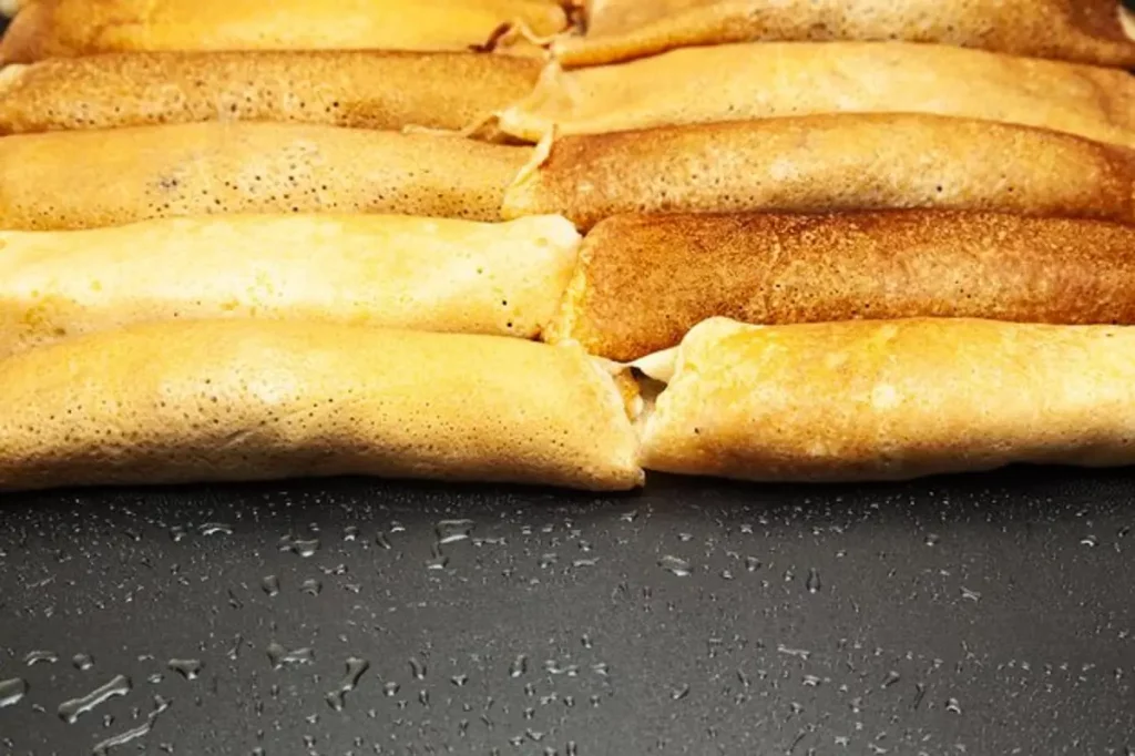 crêpes dorées empilées, pâte lisse, poêle chaude